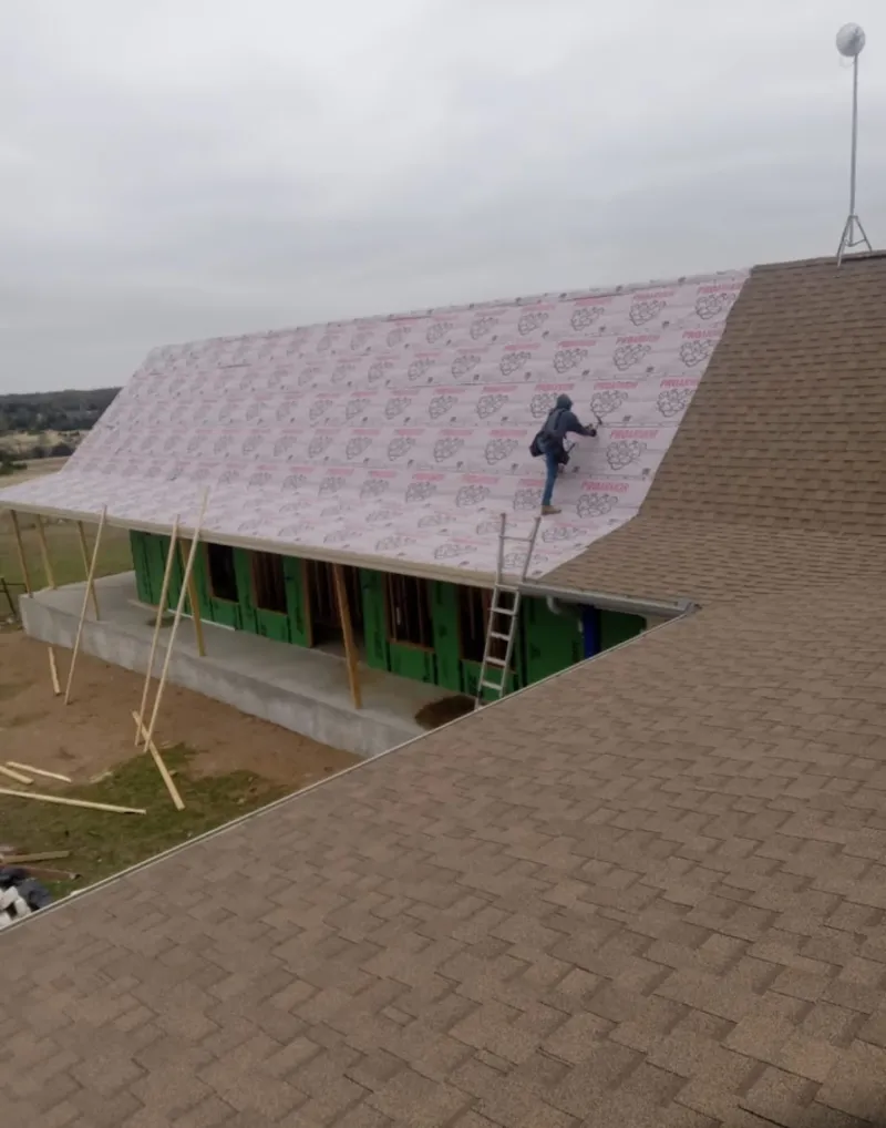 Worker preparing underlayment for a metal roof installation in San Luis Obispo